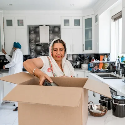 Família organizando mudança em casa comunica recomeço, necessidades reais de imigrante e construção de nova vida.